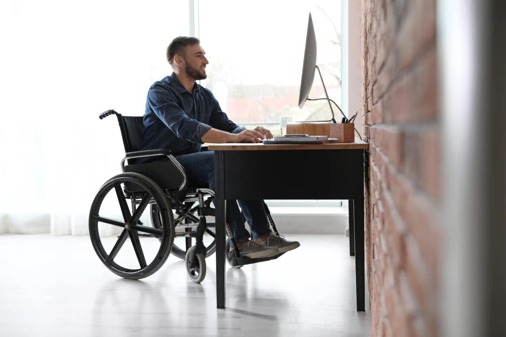 Disabled worker at a desk, representing workers compensation and disability claim help from Hussain & Gutierrez Law.